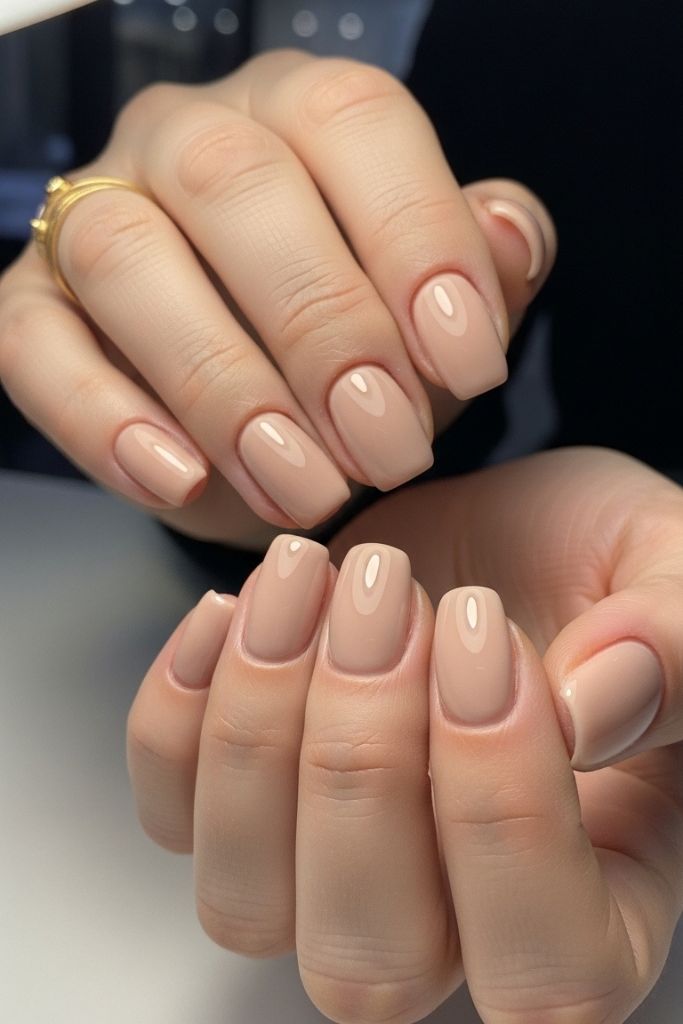 Female hands with nude beige dip powder nails, glossy and elegant.