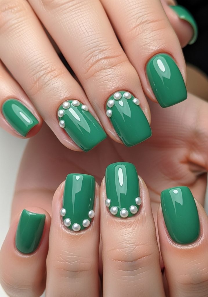 Jade green nails with small pearl studs near the cuticle on accent fingers