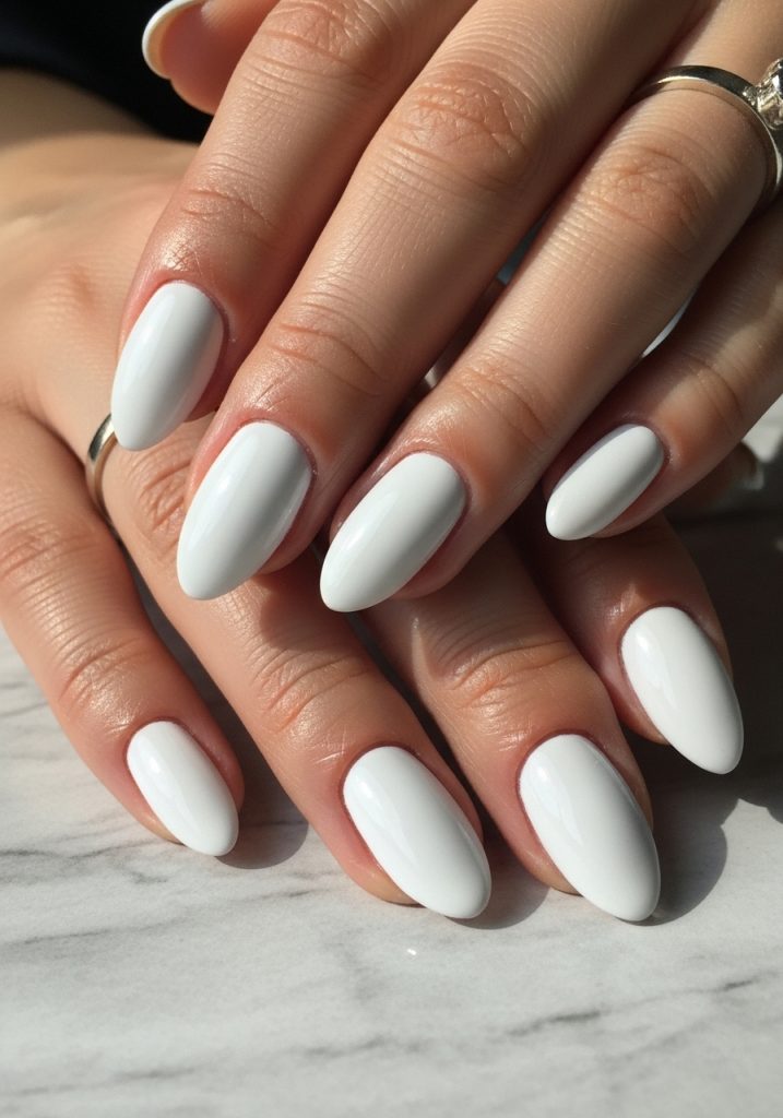 Short almond shaped white chrome mirror finish prom nails on light grey marble