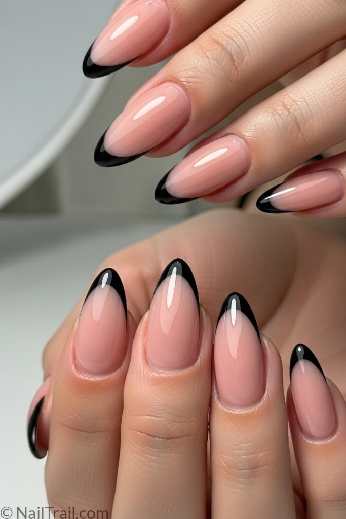 Almond-shaped black French tip nails with nude base