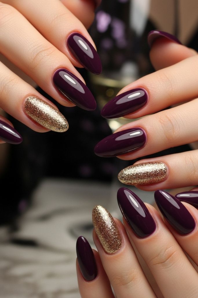 Dark purple nails with gold glitter accents for a luxurious look