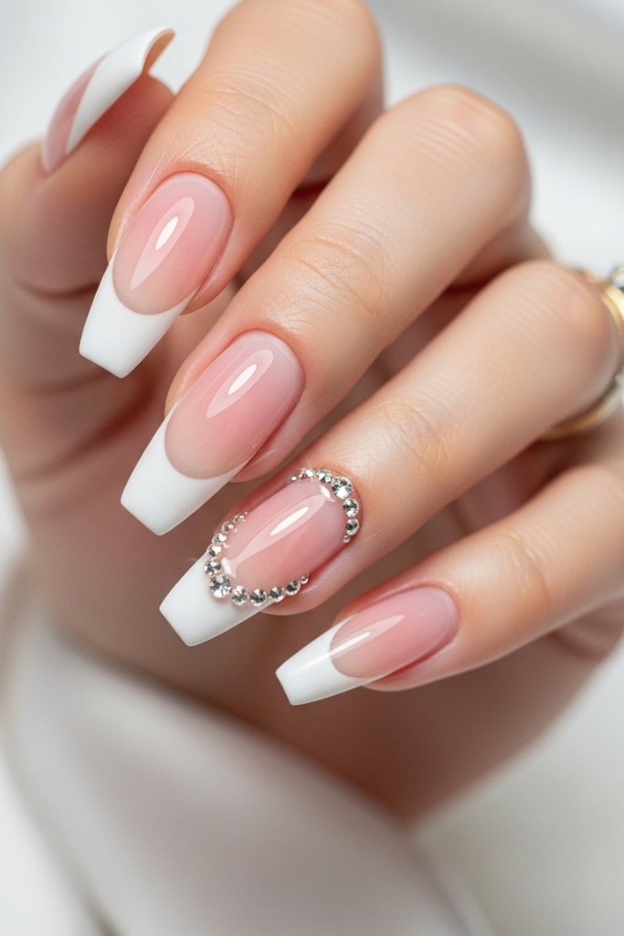 French tip acrylic nails with rhinestones on soft pink base