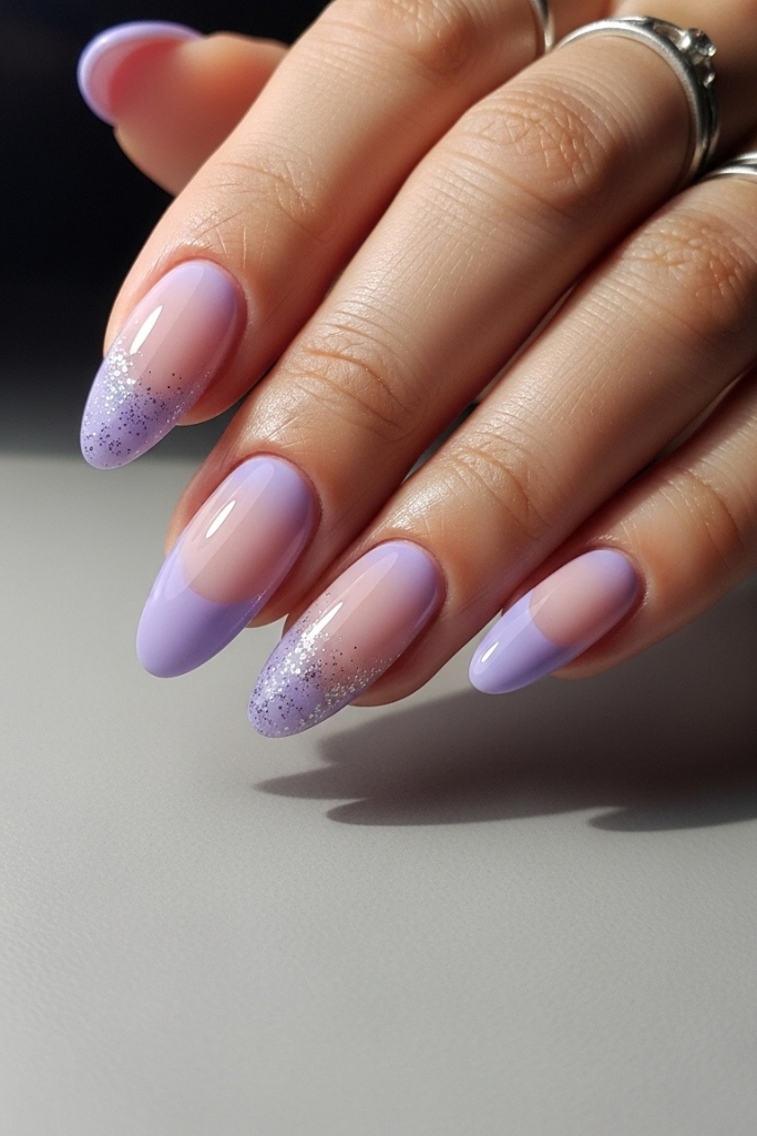 Glossy lavender nails with subtle gradient and glitter accents