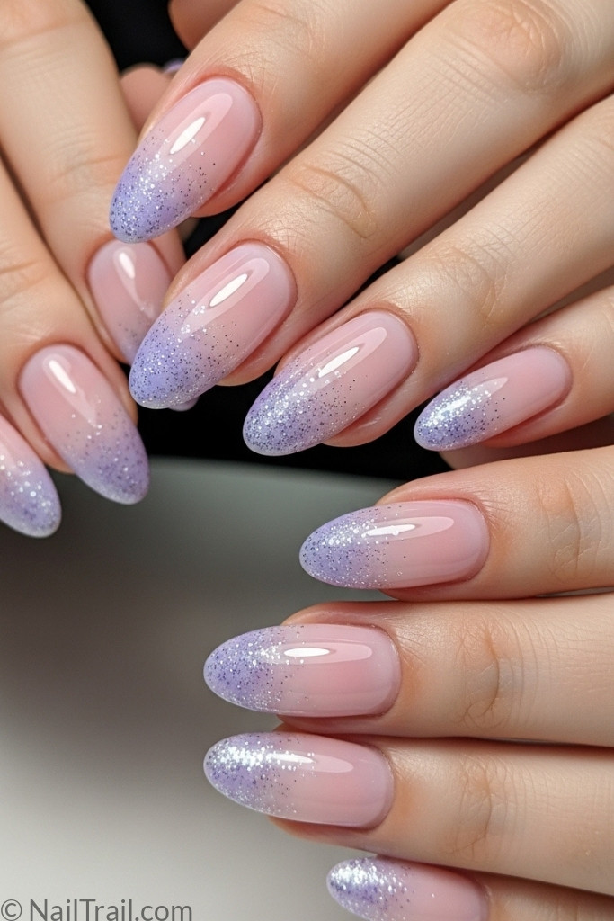 Ombre nails blending pink to lavender with glitter tips