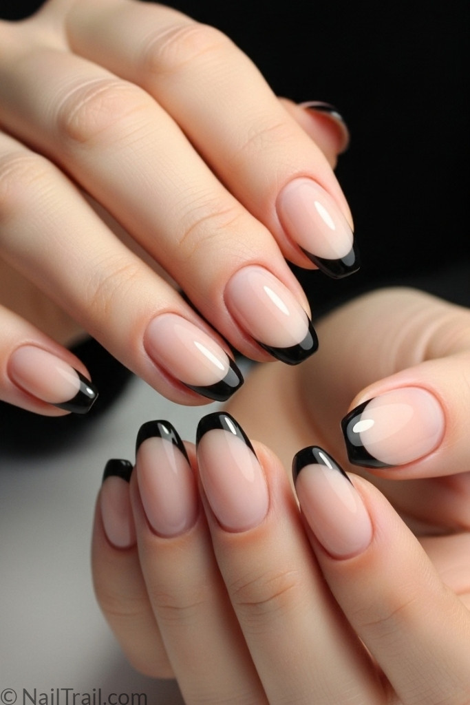 Short almond-shaped black French tip nails with nude base