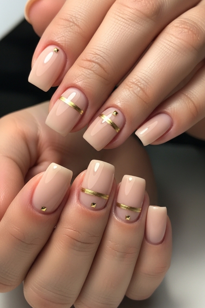Classy nude nails with subtle gold accents, elegant and sophisticated design