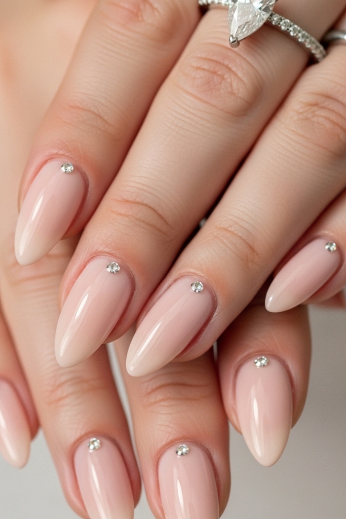 Blush nails with pear shaped engagement ring and crystal accent