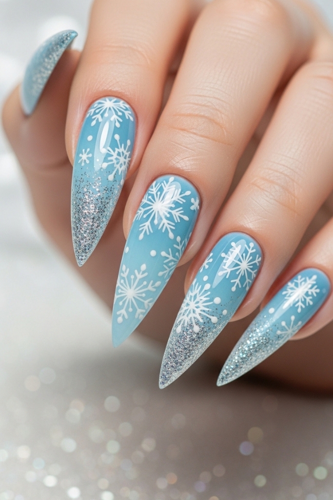 Icy blue Elsa inspired glitter nails with snowflake design.