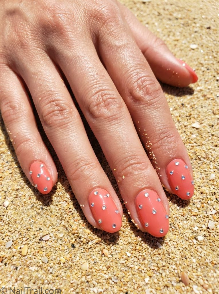 vacation nails ideas coral short oval scattered rhinestone gems glossy festive celebratory beach